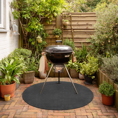 Round BBQ and grill floor protection mat on outdoor garden decking