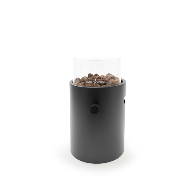 A black cylindrical portable fire pit with a clear glass wind guard and visible wood pellets, set against a plain white background.