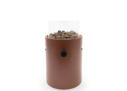 A coral red cylindrical portable fire pit with a clear glass wind guard and visible wood pellets, set against a plain white background.